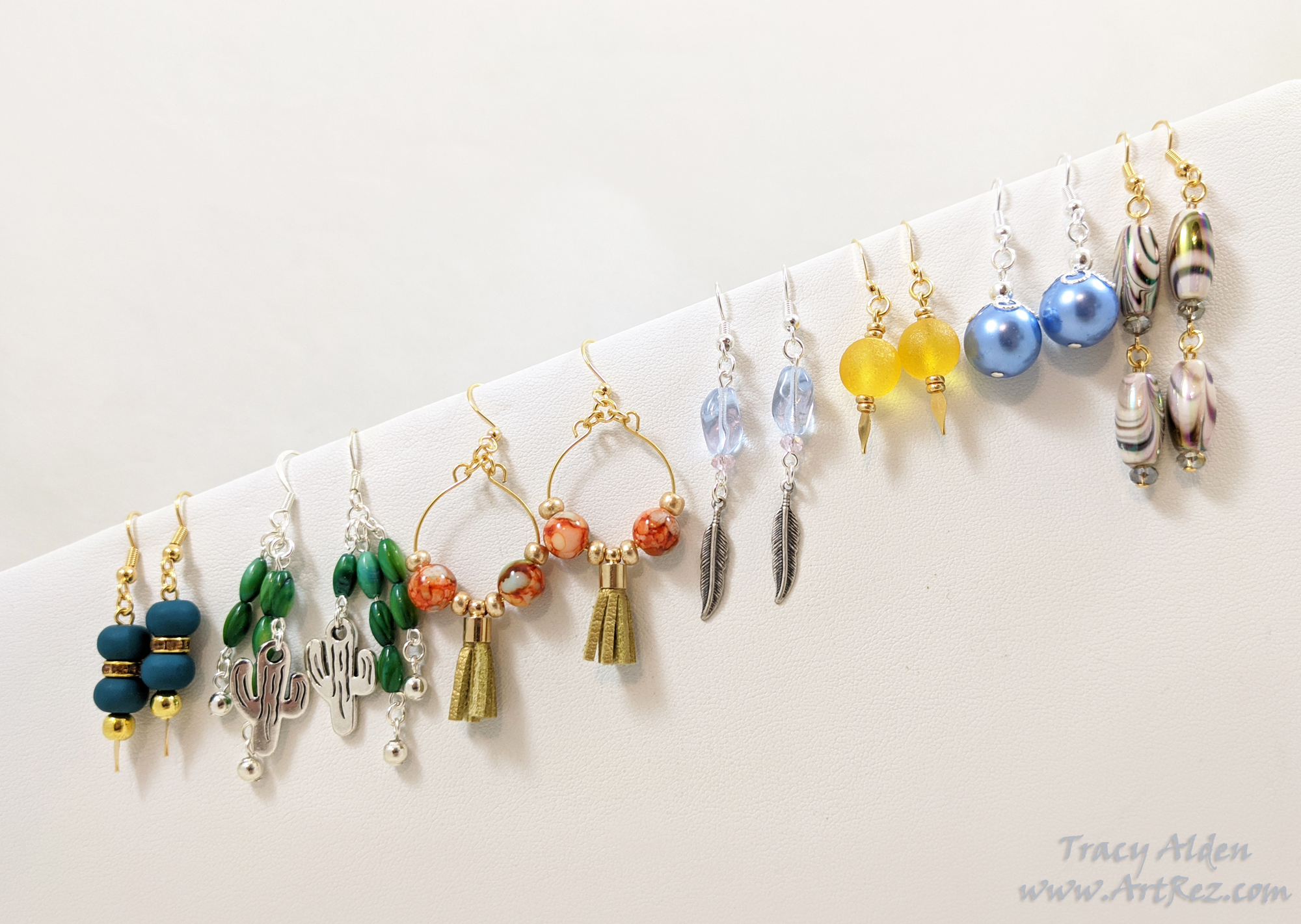 Earring assortment with gold and silver paired with blue, green, yellow and white Jesse James Beads